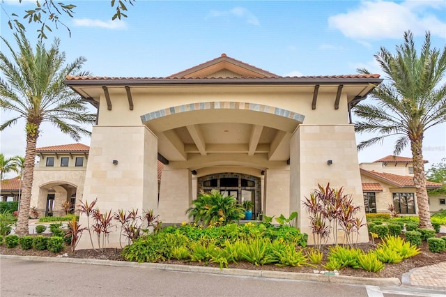 exterior space featuring stucco siding and a tiled roof