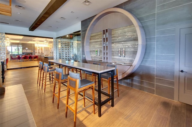 dining area featuring beamed ceiling, visible vents, and wood finished floors