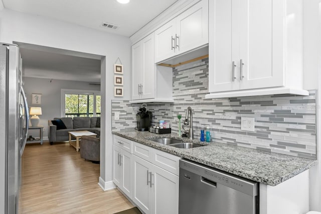 kitchen with visible vents, tasteful backsplash, appliances with stainless steel finishes, white cabinetry, and a sink