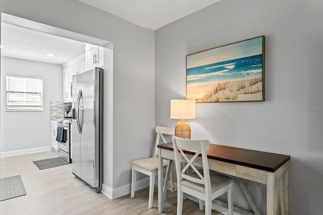 office space featuring baseboards and light wood finished floors