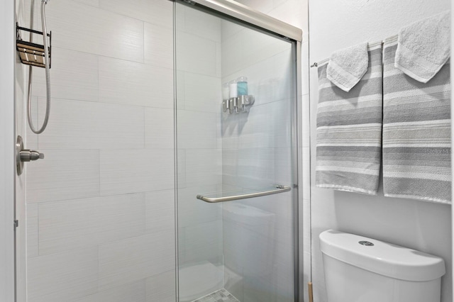 bathroom with a shower stall and toilet