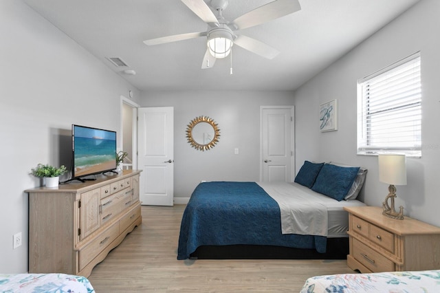 bedroom featuring light wood-style flooring, ceiling fan, and visible vents