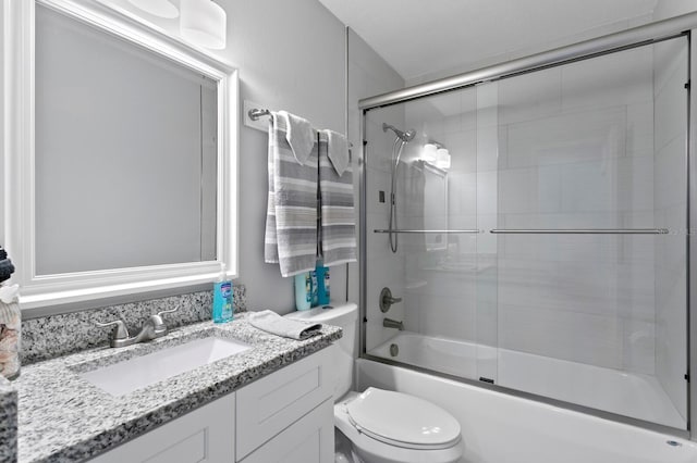 full bathroom featuring bath / shower combo with glass door, toilet, and vanity