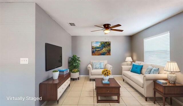 living area with light tile patterned floors, visible vents, baseboards, and a ceiling fan