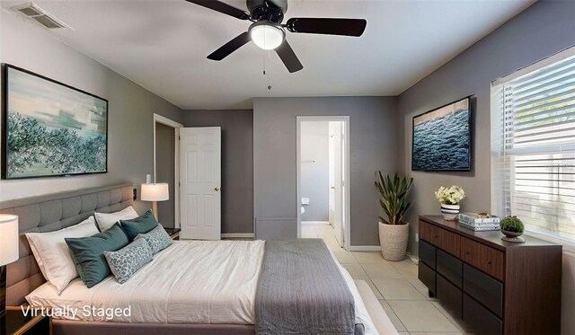 bedroom with visible vents, connected bathroom, light tile patterned flooring, baseboards, and ceiling fan