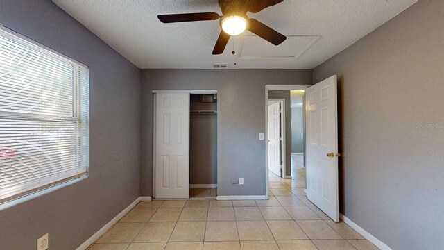 unfurnished bedroom with light tile patterned flooring, baseboards, and a closet