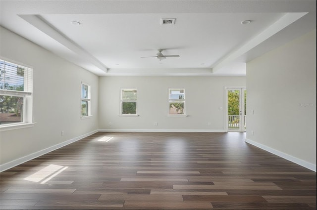 4559 Mitcher Rd, New Port Richey, FL 34652 - spare room with a tray ceiling, plenty of natural light, dark wood-style flooring, and a ceiling fan