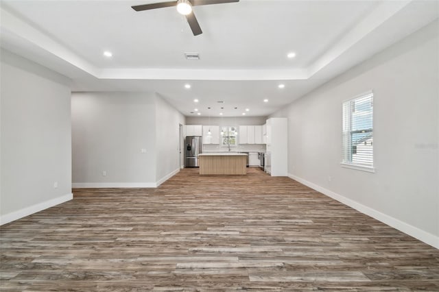 4559 Mitcher Rd, New Port Richey, FL 34652 - unfurnished living room with wood finished floors, recessed lighting, ceiling fan, and a tray ceiling