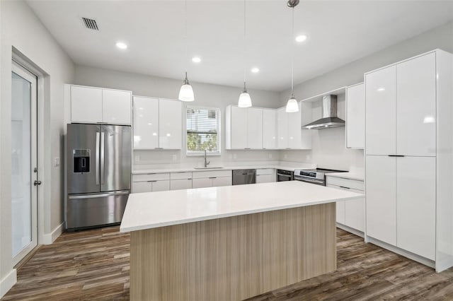 4559 Mitcher Rd, New Port Richey, FL 34652 - kitchen with stainless steel appliances, wall chimney exhaust hood, dark wood-type flooring, modern cabinets, and recessed lighting