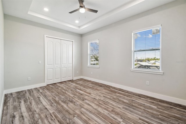 4559 Mitcher Rd, New Port Richey, FL 34652 - unfurnished bedroom with wood finished floors, a tray ceiling, recessed lighting, a closet, and ceiling fan