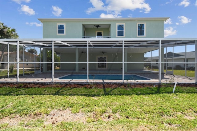 4559 Mitcher Rd, New Port Richey, FL 34652 - rear view of house with a balcony, a ceiling fan, stucco siding, a yard, and an outdoor pool