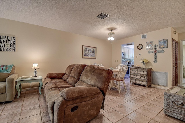 1500 Sunset Rd Unit G4, Tarpon Springs, FL 34689 - living room featuring light tile patterned flooring, visible vents, and a textured ceiling