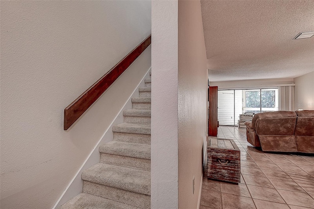 1500 Sunset Rd Unit G4, Tarpon Springs, FL 34689 - stairs with tile patterned flooring, a textured wall, visible vents, and a textured ceiling