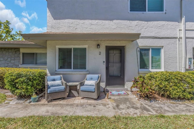 property entrance with a patio and stucco siding