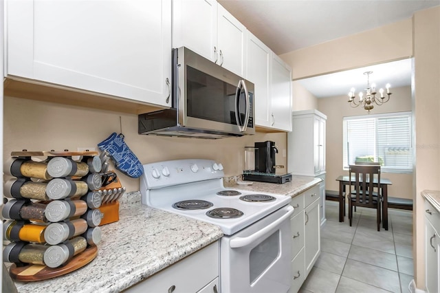 kitchen with stainless steel microwave, light tile patterned floors, a notable chandelier, white cabinetry, and electric range