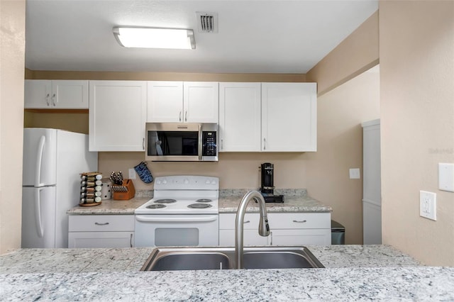 1830 Bough Ave Unit 2, Clearwater, FL 33760 - kitchen featuring white appliances, white cabinetry, and light stone countertops