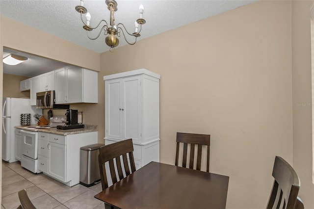 1830 Bough Ave Unit 2, Clearwater, FL 33760 - dining room featuring a chandelier, light tile patterned flooring, and a textured ceiling