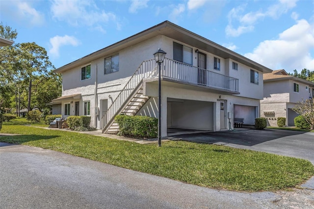 1830 Bough Ave Unit 2, Clearwater, FL 33760 - view of front of home featuring stucco siding, a front lawn, an attached garage, driveway, and stairs