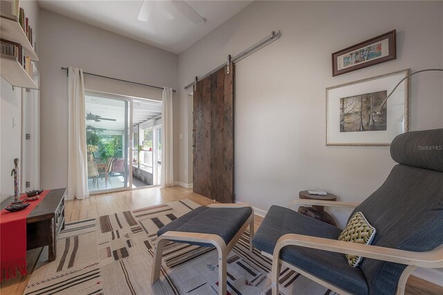 604 W Hilda St, Tampa, FL 33603 - sitting room featuring ceiling fan, wood finished floors, a barn door, and baseboards