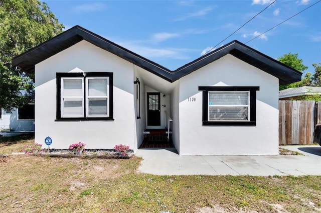 1138 Howard St, Clearwater, FL 33756 - view of front of house featuring stucco siding, fence, and entry steps