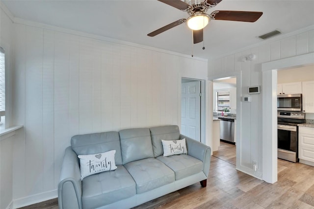 1138 Howard St, Clearwater, FL 33756 - living area featuring ceiling fan, ornamental molding, light wood finished floors, and visible vents