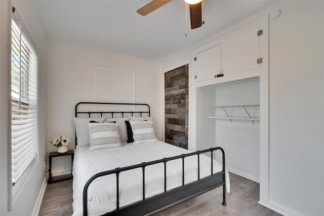 1138 Howard St, Clearwater, FL 33756 - bedroom featuring a closet, baseboards, wood finished floors, and a ceiling fan