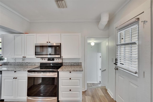 1138 Howard St, Clearwater, FL 33756 - kitchen featuring light wood-type flooring, white cabinets, light stone countertops, and stainless steel appliances