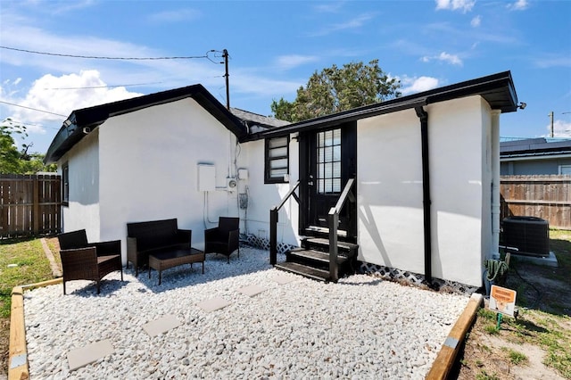 1138 Howard St, Clearwater, FL 33756 - rear view of property with stucco siding, fence, central AC, and entry steps