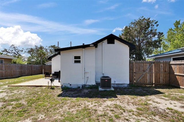 1138 Howard St, Clearwater, FL 33756 - back of property with a patio area, cooling unit, stucco siding, a fenced backyard, and a lawn