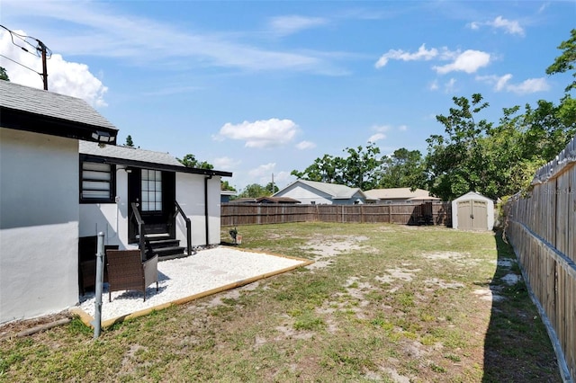 1138 Howard St, Clearwater, FL 33756 - view of yard with an outbuilding, a fenced backyard, entry steps, a patio, and a storage unit