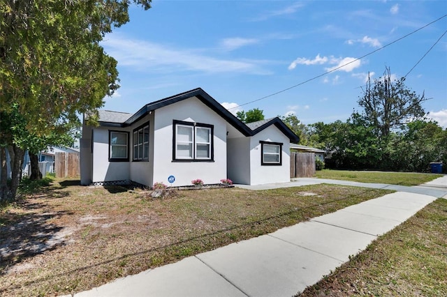 1138 Howard St, Clearwater, FL 33756 - view of front of property featuring a front yard, stucco siding, and fence
