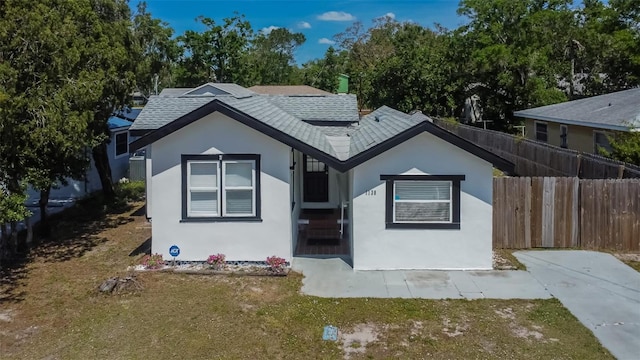 1138 Howard St, Clearwater, FL 33756 - view of front of home with stucco siding, fence, and roof with shingles