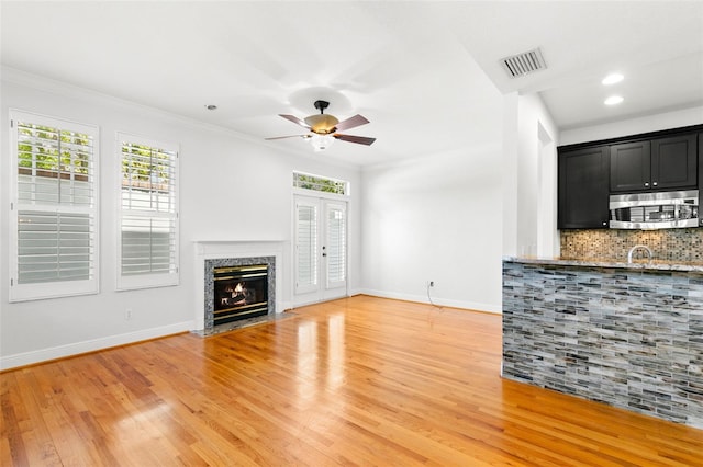 unfurnished living room featuring visible vents, baseboards, and a healthy amount of sunlight