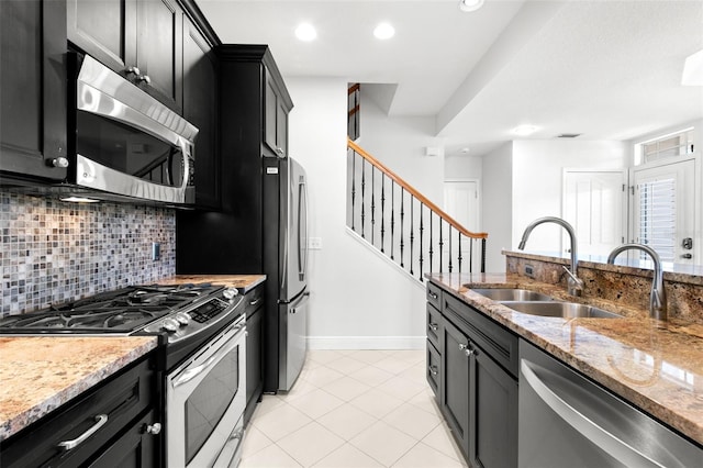 kitchen featuring light stone countertops, dark cabinets, tasteful backsplash, recessed lighting, and appliances with stainless steel finishes