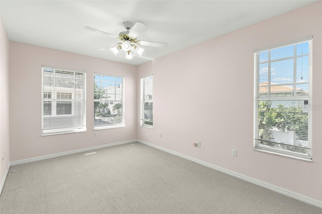 spare room featuring baseboards, ceiling fan, and light carpet