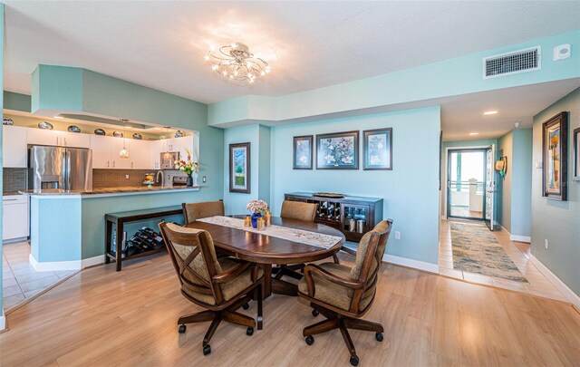 4801 Osprey Dr S Unit 508, Saint Petersburg, FL 33711 - dining area featuring baseboards, light wood-style flooring, visible vents, and a chandelier