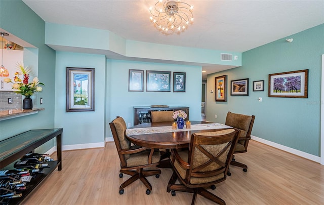 4801 Osprey Dr S Unit 508, Saint Petersburg, FL 33711 - dining space with light wood finished floors, baseboards, visible vents, and a chandelier