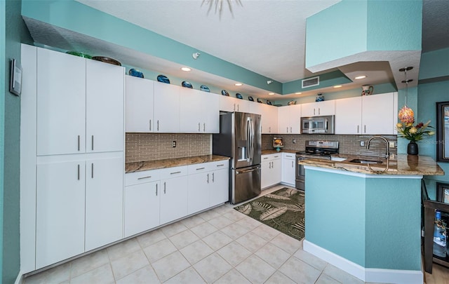 4801 Osprey Dr S Unit 508, Saint Petersburg, FL 33711 - kitchen with decorative backsplash, visible vents, a peninsula, stainless steel appliances, and a sink