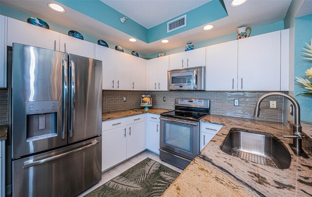 4801 Osprey Dr S Unit 508, Saint Petersburg, FL 33711 - kitchen featuring tasteful backsplash, stainless steel appliances, a sink, light stone counters, and visible vents