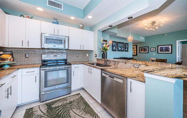 4801 Osprey Dr S Unit 508, Saint Petersburg, FL 33711 - kitchen featuring a sink, backsplash, appliances with stainless steel finishes, a peninsula, and visible vents