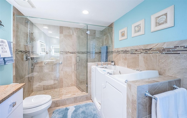 4801 Osprey Dr S Unit 508, Saint Petersburg, FL 33711 - bathroom with vanity, tile walls, toilet, a shower stall, and a bath