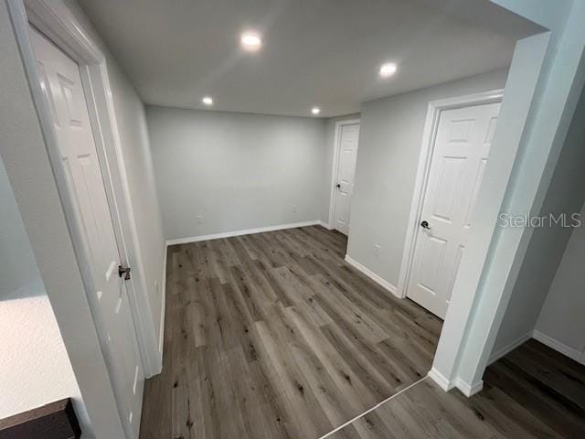 interior space with baseboards, wood finished floors, and recessed lighting