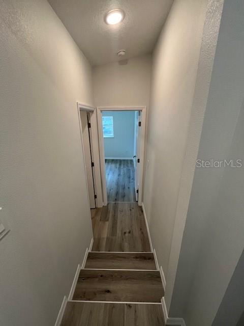 staircase featuring baseboards and wood finished floors