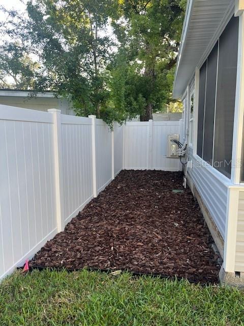 view of yard featuring a sunroom and a fenced backyard