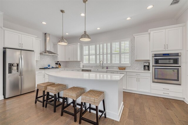 16306 1st St E, Redington Beach, FL 33708 - kitchen featuring light countertops, a sink, visible vents, appliances with stainless steel finishes, and wall chimney exhaust hood