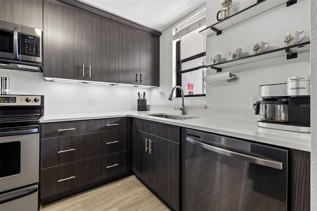 1998 Blue Hawk Ct Unit 1613, Clearwater, FL 33762 - kitchen featuring appliances with stainless steel finishes, a sink, a textured ceiling, light countertops, and dark brown cabinetry