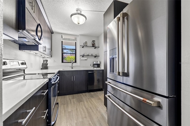 1998 Blue Hawk Ct Unit 1613, Clearwater, FL 33762 - kitchen with appliances with stainless steel finishes, a sink, light wood-style flooring, light countertops, and a textured ceiling