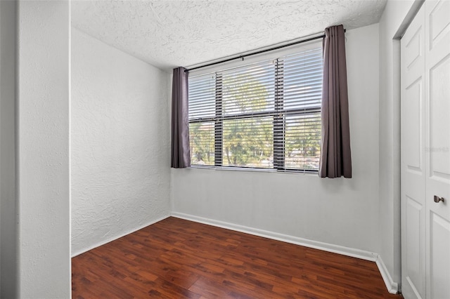 1998 Blue Hawk Ct Unit 1613, Clearwater, FL 33762 - unfurnished room featuring a textured ceiling, dark wood finished floors, baseboards, and a textured wall