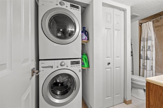 1998 Blue Hawk Ct Unit 1613, Clearwater, FL 33762 - laundry room featuring estacked washer and dryer, a textured ceiling, and tile patterned flooring