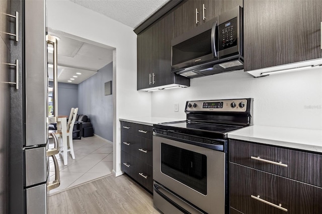 1998 Blue Hawk Ct Unit 1613, Clearwater, FL 33762 - kitchen with stainless steel appliances, light countertops, and dark brown cabinetry